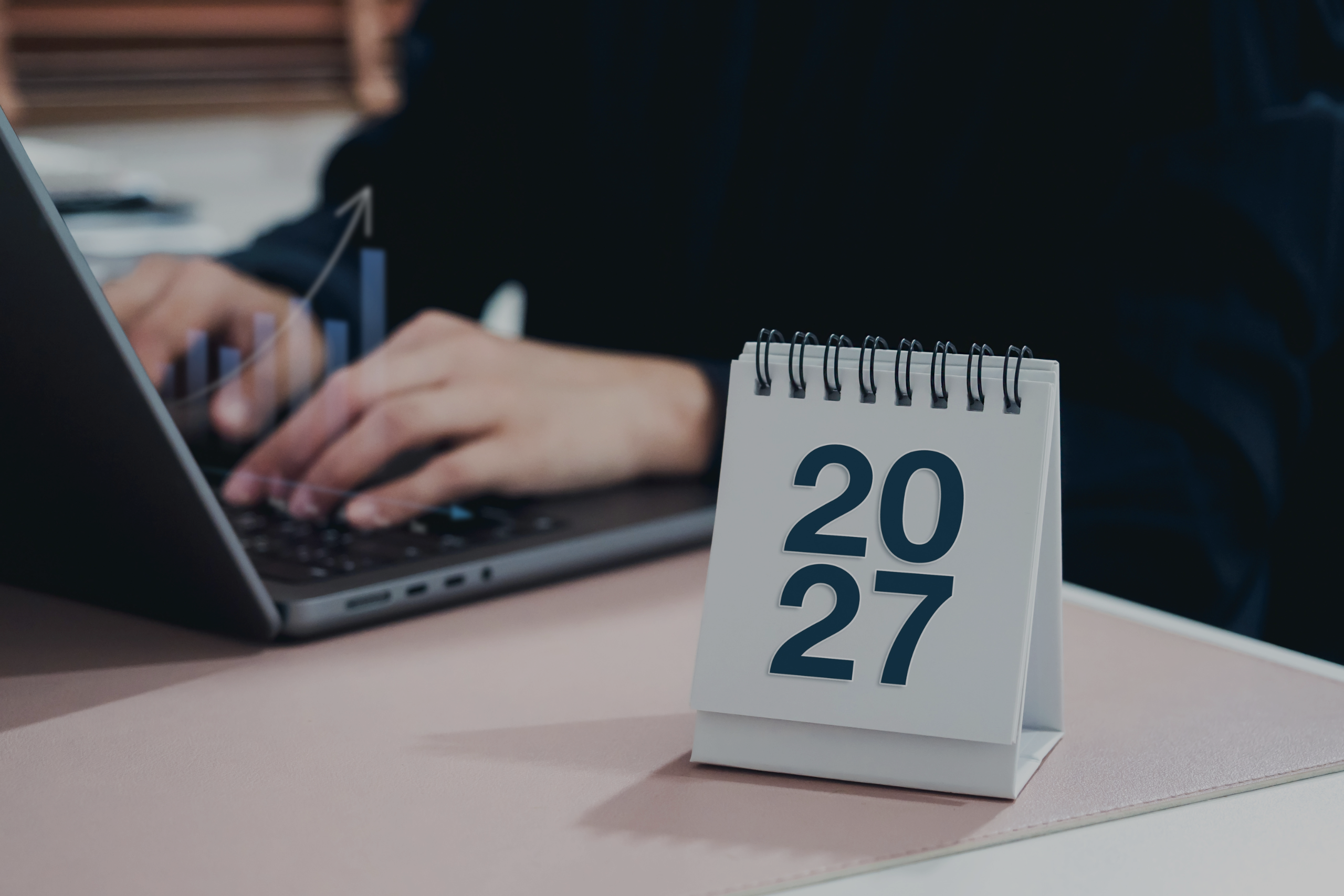Férfi laptop előtt ül 2027-es naptárral